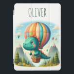 Protection iPad Pro Cover Cute Dinosaur volant dans un ballon à air chaud<br><div class="desc">Laissez votre petit explorateur monter au-dessus des nuages avec cette couverture iPad personnalisée avec un charmant dinosaure dans une aventure de montagne magique ! Imaginez une montgolfière vibrante qui dérive au-dessus de sommets majestueux, créant une scène fantasque. Il est également personnalisé de façon unique avec le nom de votre enfant,...</div>