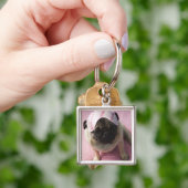 Pug hond met oogmasker op het hoofd dat op bed zit sleutelhanger (Hand)