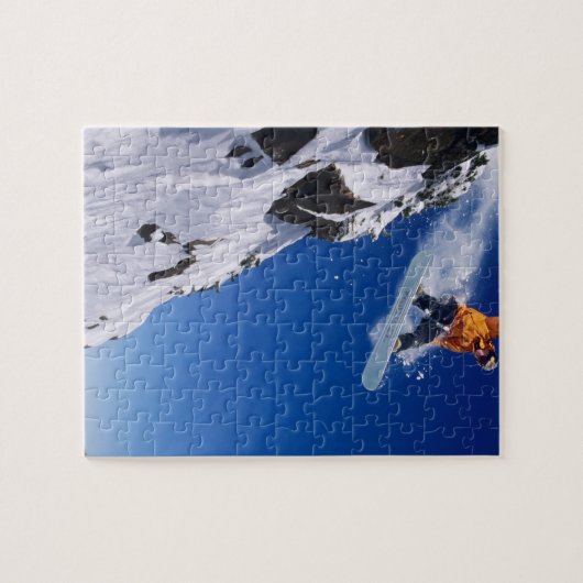 Puzzle Un homme en snowboard sautant d'une corniche à (Horizontal)