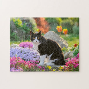 Puzzle Un joli chat noir blanc dans un jardin fleuri colo