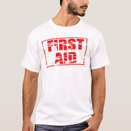 Red rubber stamp effect. First Aid.  T-shirt (Voorkant)
