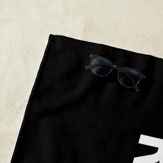 RÉSERVÉ, texte blanc sur la serviette Black Beach (En situation)