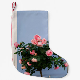 Rode bloemen met groene bladeren op blauwe wand kleine kerstsok