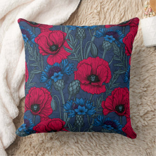 Rode papaver en blauwe cornbloemen op blauw kussen