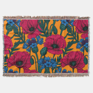 Rode papaver en blauwe cornbloemen op sinaasappel deken
