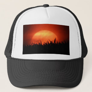 Rode zonsondergang achter zwart gras trucker pet