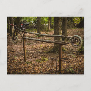 Roestig fietsframebeeldhouwwerk in het bos briefkaart