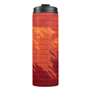 Rood en oranje geschilderde bakstenen muur thermosbeker