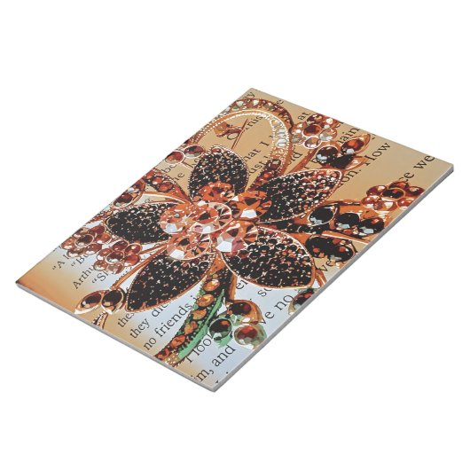 Rood goud edelstenen sieraden op print achtergrond notitieblok (Schuin)