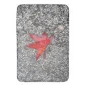 Rood herfst blad in regen op grijze, getextureerde badmat (Voorkant Verticaal)