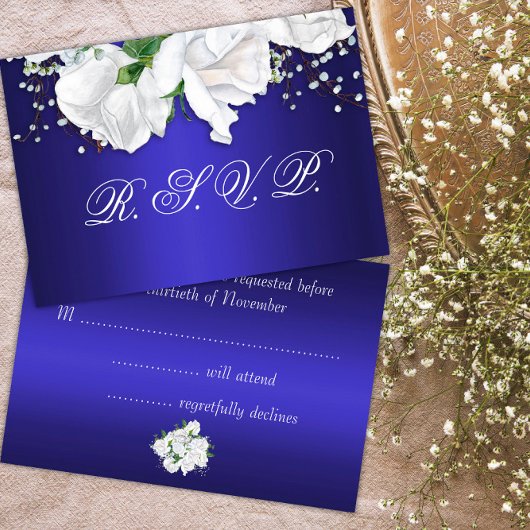 Roses blanches luxueuses et carte RSVP bleu foncé