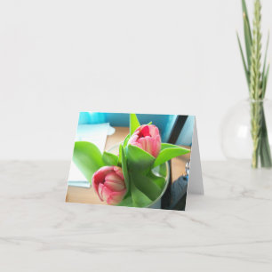 Roze desktoptulpen op een lege notitiekaart