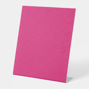 Roze gestructureerd oppervlak met subtiel draaiend reclamebord met voetstuk