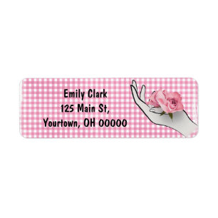 roze roos in hand op geruit etiket