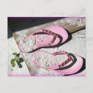 Roze zandige flip flop-sandalen op het strand van briefkaart