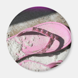 Roze zandige flip flop-sandalen op het strand van  magneet