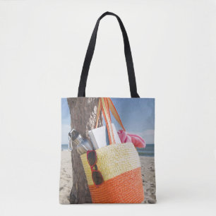 Sac accrochant sur le tronc d'arbre à la plage