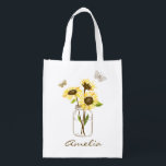 Sac Réutilisable Tournesols dans le pot de maçon personnalisé<br><div class="desc">Sac réutilisable personnalisable féminin et élégant comportant les tournesols jaunes dans le pot de maçon avec des accents de papillon. Personnalisez ce sac fourre-tout floral en ajoutant des noms ou l'expression courte. Perfectionnez pour des demoiselles d'honneur et comme cadeau personnalisé pour des occasions spéciales.</div>