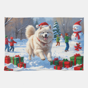 Samojed die in de sneeuw rent met een kerstmuts theedoek