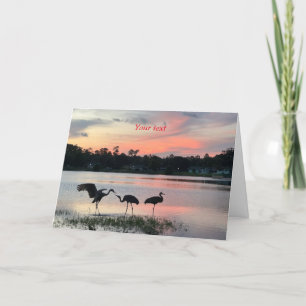 Sandhill kranen silhouet bij zonsondergang bij het feestdagen kaart