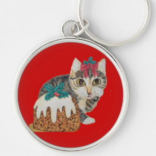 Schattig grijs kitten likken poot met kerst sleutelhanger