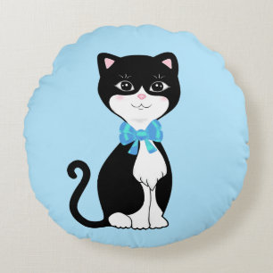 Schattige gelukkige tuxedo kat op lichtblauw rond kussen