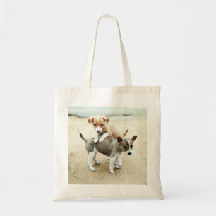 Schattige honden spelen op het strand tote bag