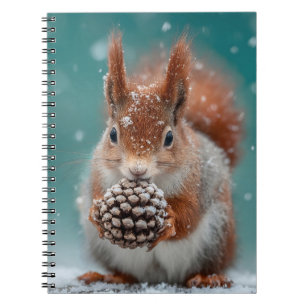 Schattige rode eekhoorn in de sneeuw met een pinec notitieboek