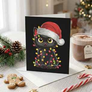 Schattige zwarte kat in kerstmuts met kerstverlich feestdagenkaart