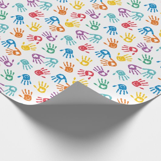 Schattigee veelkleurige geschilderde handen op wit cadeaupapier (Hoek)