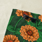 Serviette De Plage Fleurs Zinnia orange, feuilles verts sur vert fonc (En situation)