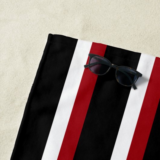 Serviette de plage rayée noir rouge et blanc (En situation)