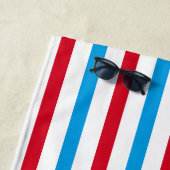 Serviette de plage rayée rouge, blanche et bleue (En situation)