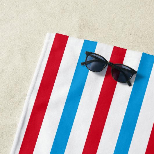 Serviette de plage rayée rouge, blanche et bleue (En situation)