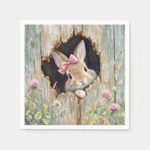 Serviette En Papier Lapin avec un nœud rose dans un trou de clôture