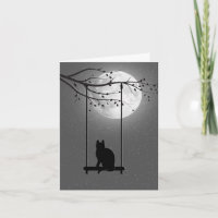 Silhouet kat op een schommel in maanlicht