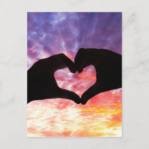 Silhouette hand in hartvorm en mooie hemel briefkaart
