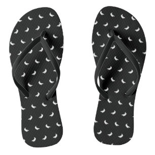 Silhouetten van kleine witte bananen op zwart teenslippers