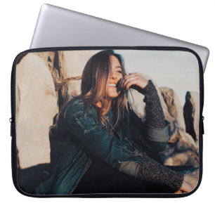 Sitting en glimlachte vrouw met zwarte broek laptop sleeve