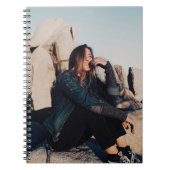 Sitting en glimlachte vrouw met zwarte broek notitieboek (Voorkant)