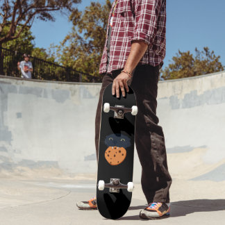 Skateboard chat noir tenant un biscuit dans les dents