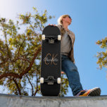 Skateboard Écriture en or noir monogramme élégant minimaliste<br><div class="desc">Un arrière - plan noir classique. Personnalisez et ajoutez un nom et des initiales monographiques. Le nom est écrit avec un script de style moderne écrit à la main. Lettres blanches et dorées.</div>