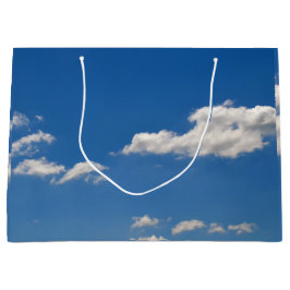 Sky is blauw en witte wolken gaan langs groot cadeauzakje