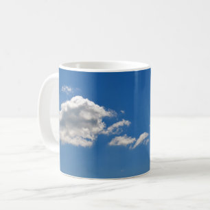 Sky is blauw en witte wolken gaan langs koffiemok