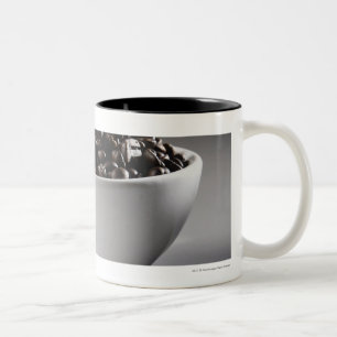 Sluiting van een kom vol koffiebonen tweekleurige koffiemok