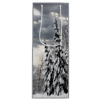Sneeuw bedekte groenblijvende bomen onder dramatis wijn cadeautas