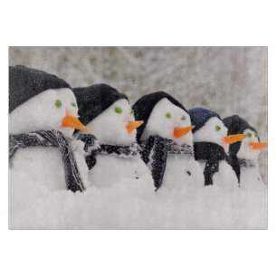 Sneeuwmannen sluiten op rij snijplank