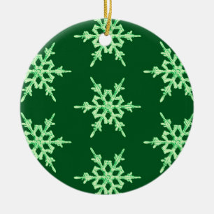 Sneeuwvlokken, bleke groene kristallen op donkergr keramisch ornament