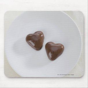 Snoepjes van harsvormige chocolade op een bord muismat