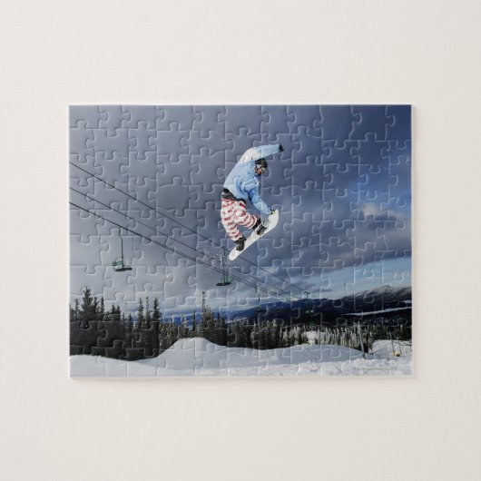 Snowboarder die in de lucht springt en een achterk legpuzzel (Horizontaal)